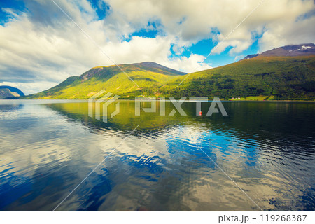 Mountain landscape with cloudy sky. Majestic Geiranger fjord. Reflection in the water. Beautiful nature of Norway. Mountain landscape with cloudy sky. Majestic Geiranger fjord. Reflection in the water. Beautiful nature of Norway. 119268387