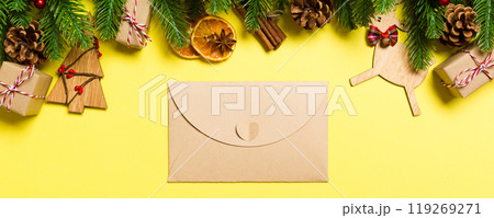 Top view of envelope on yellow background. New Year decorations. Christmas holiday concept Top view of envelope on yellow background. New Year decorations. Christmas holiday concept 119269271