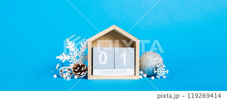1 january. Christmas composition on colored background with a wooden calendar, with a gift box, toys, bauble copy space 1 january. Christmas composition on colored background with a wooden calendar, with a gift box, toys, bauble copy space 119269414