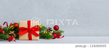 New Year Christmas mood, gift box, branches of a christmas tree, New Year decorations on a colored background 119269505