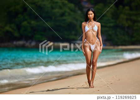 Beautiful asian girl in white bikini posing at the tropical beach 119269825