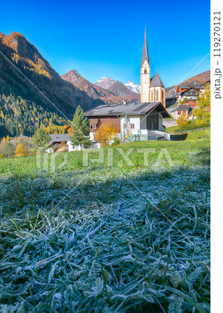 Picturesque autumn landscape  at Heiligenblut with St Vincent Church near Grossglockner mount . 119270121
