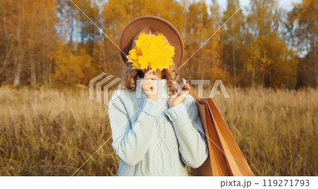 Stylish happy young woman with shopping bag, yellow leaves, girl smiling outdoors in autumn park Stylish happy young woman with shopping bag, yellow leaves, girl smiling outdoors in autumn park 119271793