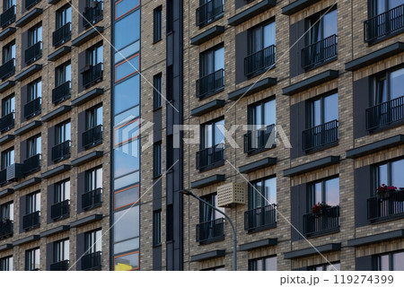 Modern high-rise apartment buildings in a residential area showcasing diverse window styles and 119274399