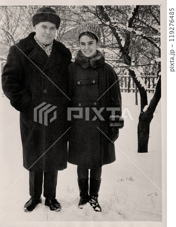 Vintage photo of dad and daughter in the winter garden. Retro photo taken in Ukraine, in Chasovoy Yar in the 1960s Vintage photo of dad and daughter in the winter garden. Retro photo taken in Ukraine, in Chasovoy Yar in the 1960s 119276485