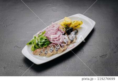 Traditional marinated herring with onion, potatoes and herbs on plate. Perfect for seafood lovers Traditional marinated herring with onion, potatoes and herbs on plate. Perfect for seafood lovers 119276699
