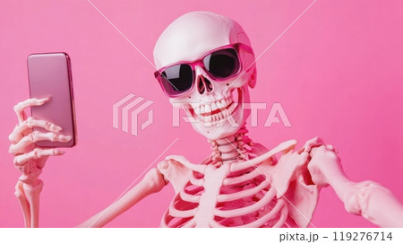 a skeleton wearing pink sunglasses, taking a selfie with a smartphone against a pink background 119276714
