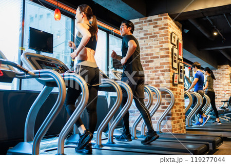 ランニングマシンでトレーニングする男女 119277044