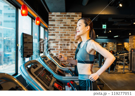 ランニングマシンでトレーニングする男女 119277051