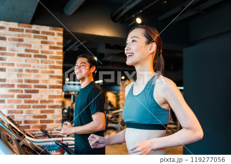 ランニングマシンでトレーニングする男女 119277056