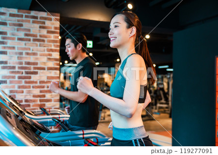 ランニングマシンでトレーニングする男女 119277091