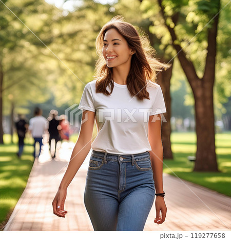 緑の木々がたくさん並んでいる公園を散歩する女性 119277658