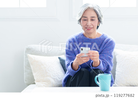 リビングでスマートフォンを使う中高年の女性 119277682