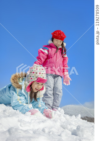 雪の公園で遊ぶ姉妹 119278509