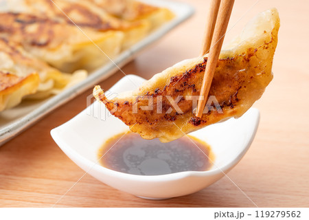タレにつけて食べる美味しそうな焼き餃子のクローズアップ 119279562