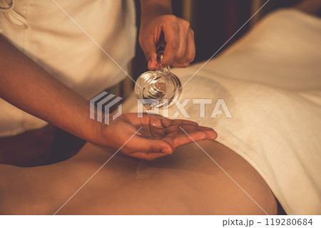 Closeup masseuse prepare oil massage procedure for customer at spa. Quiescent 119280684
