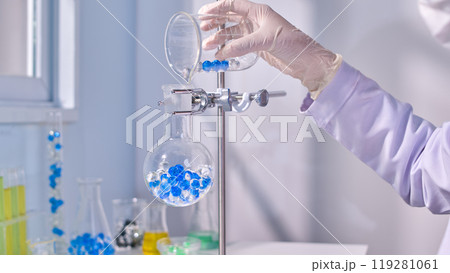 Blue and transaprent hydrogel poured into boiling flask in metal stand in modern laboratory background. Creative template photo for promotional Blue and transaprent hydrogel poured into boiling flask in metal stand in modern laboratory background. Creative template photo for promotional 119281061
