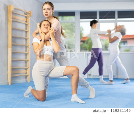 Young woman performing chokehold on female partner during self-defense training Young woman performing chokehold on female partner during self-defense training 119281149