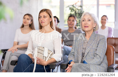 Adult and elderly woman listening to lecture in office 119281264