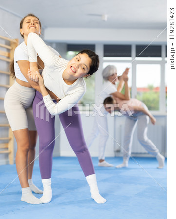 Woman and girl in gym perform basic elements of krav maga self-defense system. 119281473