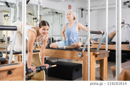 Young girl practicing pilates stretching exercises on combo chair 119281614