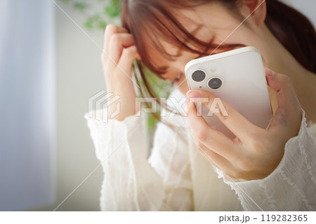 スマホを見て冴えない表情をする女性 119282365