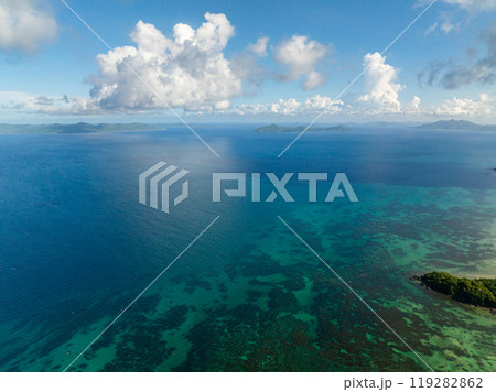 Turquoise sea water with coral reefs. Blue sky and clouds. El Nido, Philippines. 119282862