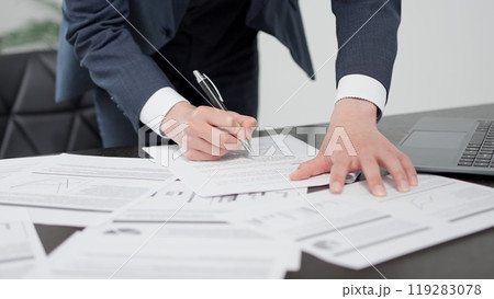 急いで資料を確認するビジネスマンの手元 119283078