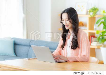 自宅でノートパソコンを操作する女性 自宅でノートパソコンを操作する女性 119286325