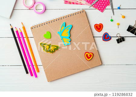 Crafting inspiration with colored pencils, decorative tape, and playful shapes on a rustic wooden surface 119286832