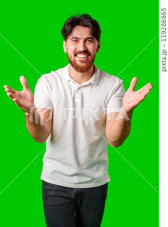 Young man expresses surprise in front of a bright green background 119286865