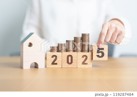 Happy New Year 2025 with house model and Coins stack. real estate, Home loan, tax, investment, mortgage, financial, savings and New Year Resolution concepts 119287484
