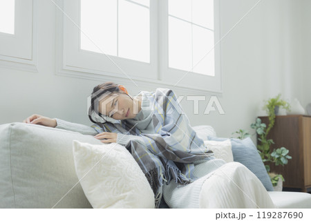 体調不良の冬のリビングの女性　　 119287690