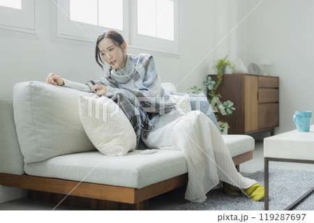 体調不良の冬のリビングの女性　　 119287697