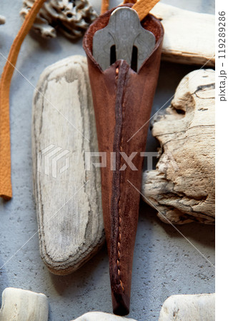 Jew's harp in a brown genuine leather case on a gray background. Sound therapy. 119289286