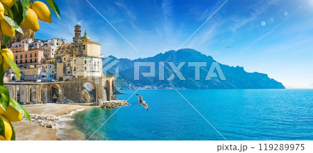 Small town Atrani on Amalfi Coast in province of Salerno, Campania region, Italy. Amalfi coast is popular travel and holyday destination in Italy. Ripe yellow lemons in foreground. 119289975