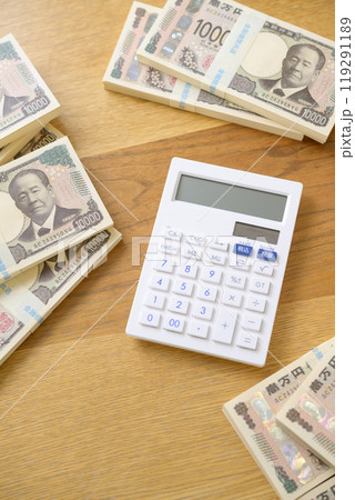 机に置かれた札束と電卓（新紙幣バージョン） 119291189