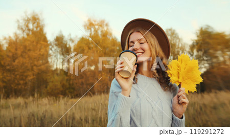 Happy young woman with yellow leaves, girl smiling holding cup of coffee drink in autumn park 119291272