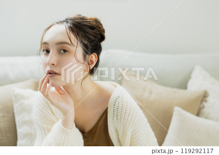部屋でくつろぐニットの女性 119292117