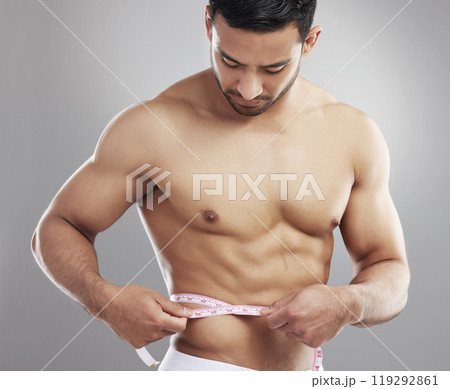 Man, tape measure and lose weight results in studio or waist size for progress, grey background or athlete. Male person, shirtless and workout training or diet for bodybuilder abs, growth or muscle 119292861