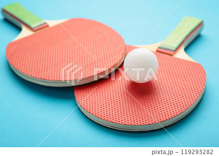 Ping pong rackets and ball on blue background Ping pong rackets and ball on blue background 119293282