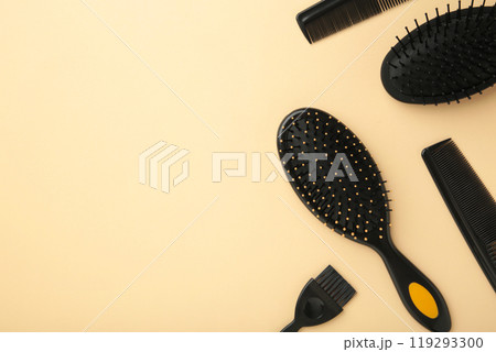 Hair tools, beauty and hairdressing concept - different brushes or combs on beige background. Hair tools, beauty and hairdressing concept - different brushes or combs on beige background. 119293300