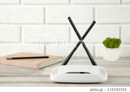 Wireless Wi-Fi router on white background with notebook Wireless Wi-Fi router on white background with notebook 119293583