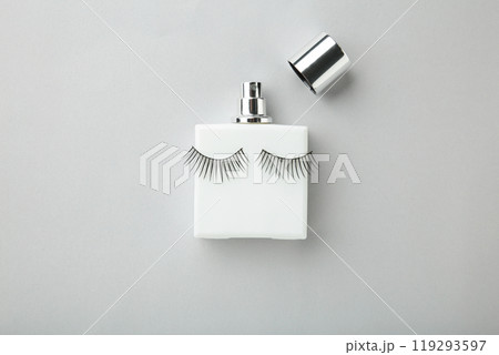 Perfume bottle with eyelashes on grey background Perfume bottle with eyelashes on grey background 119293597