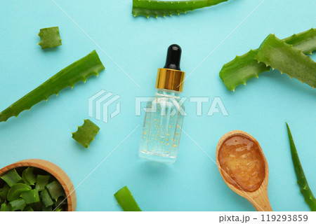 Aloe vera and oil bottle on blue background. 119293859