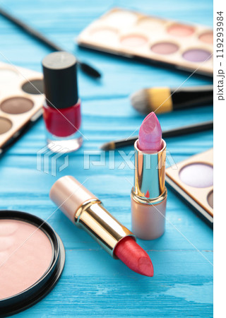 Makeup lipstick and cosmetics on blue background. Flat lay, top view. Beauty and fashion concept. Makeup lipstick and cosmetics on blue background. Flat lay, top view. Beauty and fashion concept. 119293984