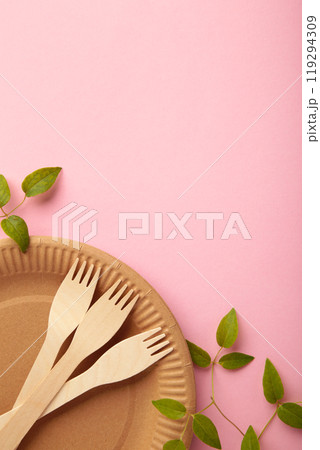 Eco friendly disposable dishes with green leaves on pink background. Zero waste, eco friendly, plastic free background. Vertical photo 119294309