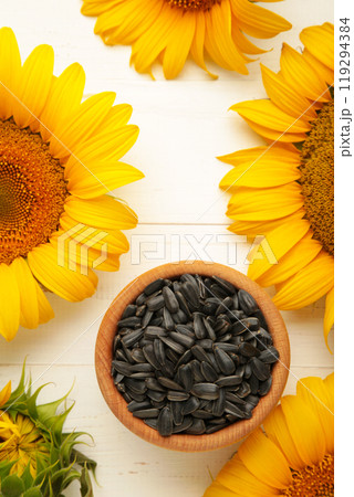 Sunflower with seeds in bowl on white wooden background 119294384