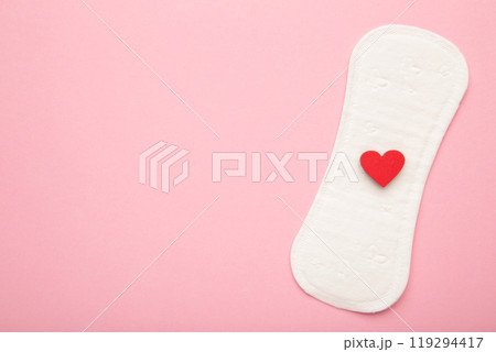 Menstrual pads on pink background. Menstruation cycle. Hygiene and protection. A heart on a menstrual pad. Menstrual pads on pink background. Menstruation cycle. Hygiene and protection. A heart on a menstrual pad. 119294417