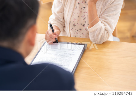 対面　契約　シニア女性　手元 119294742